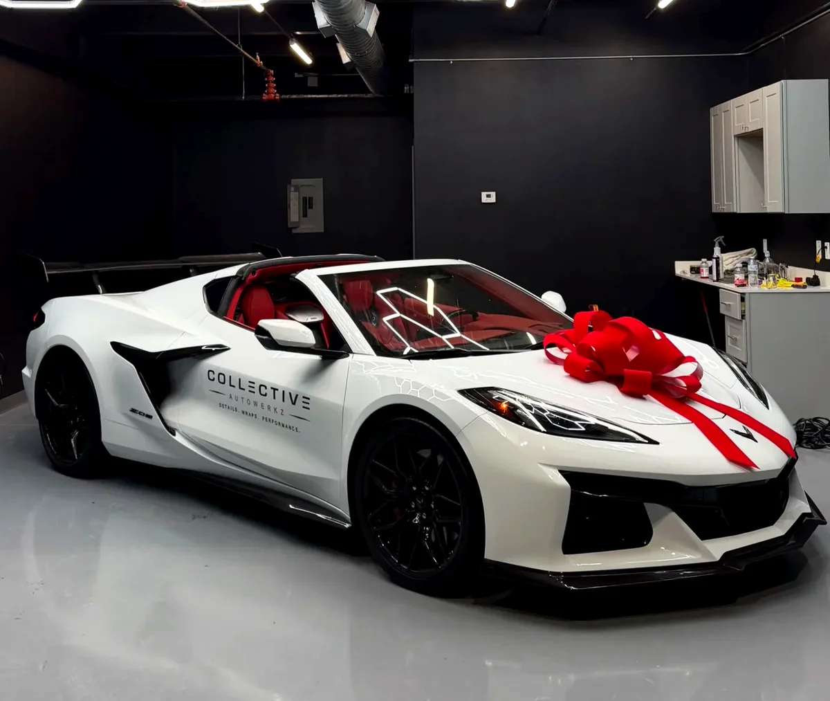 A white Corvette Z06 with Collective Autowerkz livery inside our Lewisville shop